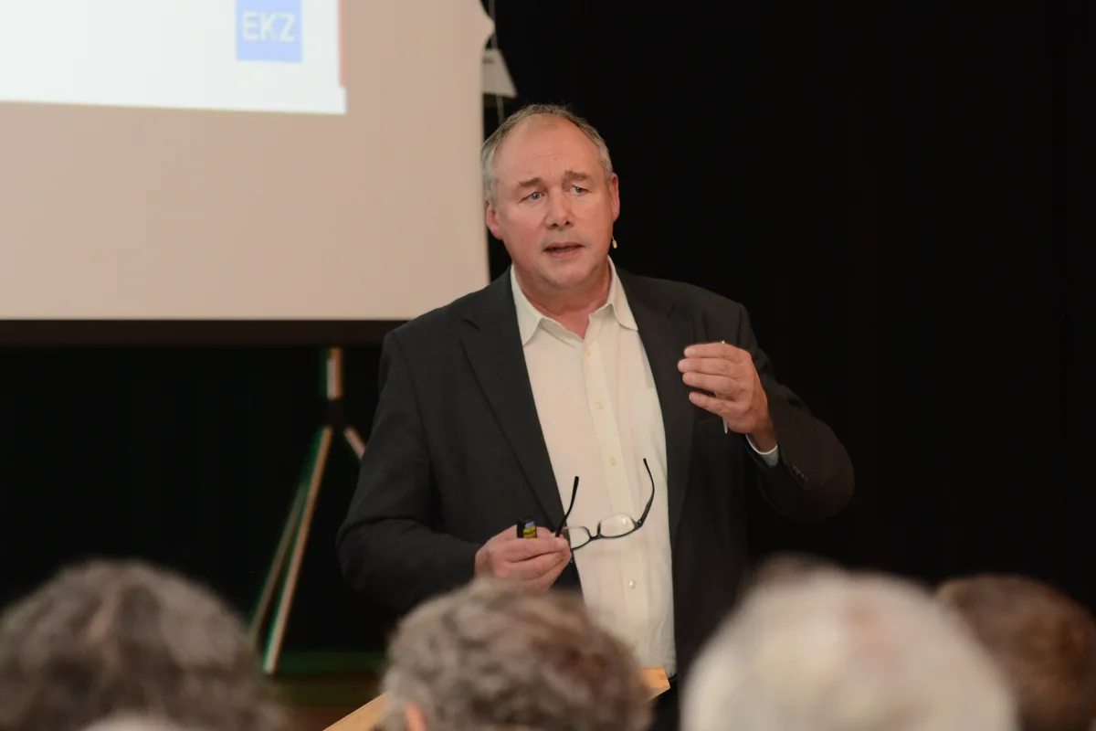 Urs Rengel am Referieren. Mann referiert an einem Podium